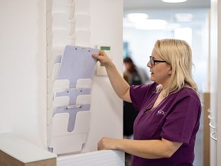 Mitarbeiterin des Praxis-Teams sortiert Patientendokumente ein