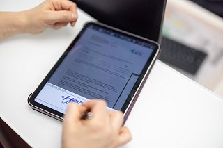 Patient unterschreibt Vertrag auf einem Tablet