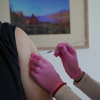 Durchführung einer Impfung am Arm eines Patienten