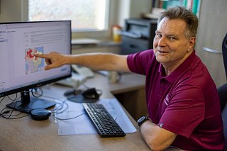 Arzt zeigt auf Landkarte am PC