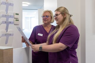 Mitarbeiterinnen des Praxis-Team sortiert Patientendokumente ein