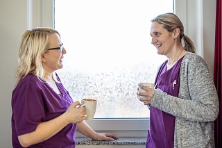 Zwei Mitarbeiterinnen des Praxis-Team besprechen sich bei einem Kaffee